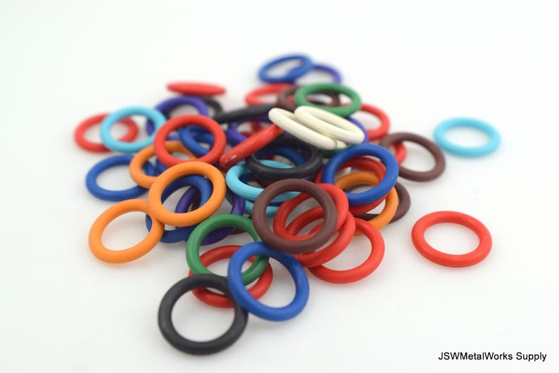 May include: A large pile of colorful plastic rings, some are red, blue, green, orange, white, and brown. The rings are all different sizes and are arranged in a random pattern.