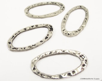 May include: Four silver oval-shaped metal rings with a hammered texture. The rings are approximately 1 inch in diameter.
