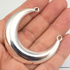 Puede incluir: Encanto de luna creciente de plata con dos agujeros para sujetar a joyas u otras manualidades.