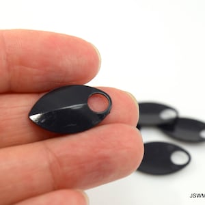 May include: Black plastic leaf-shaped charms with a hole in the center. The charms are about 1 inch long and 1/2 inch wide.