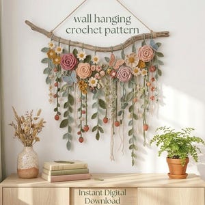 Puede incluir: Un tapiz de pared con patrón de ganchillo que presenta una rama de madera flotante adornada con flores, hojas y mariposas tejidas en tonos suaves de rosa, amarillo, verde y azul. El texto wall hanging crochet pattern e Instant Digital Download son visibles.
