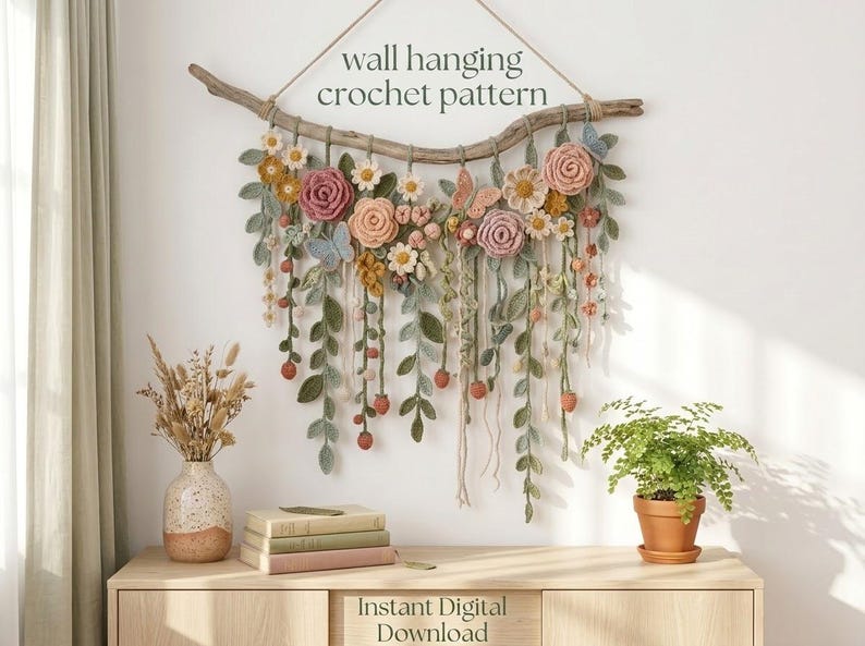 May include: A wall hanging crochet pattern featuring a driftwood branch adorned with various crocheted flowers, leaves, and butterflies in muted tones of pink, yellow, green, and blue. The text wall hanging crochet pattern and Instant Digital Download are visible.
