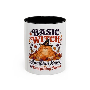 May include: A white ceramic mug with a black interior rim featuring a graphic of an orange cat wearing a witch hat sitting in a pile of autumn leaves. The text reads BASIC WITCH PUMPKIN SPICE & EVERYTHING NICE in purple and orange lettering.