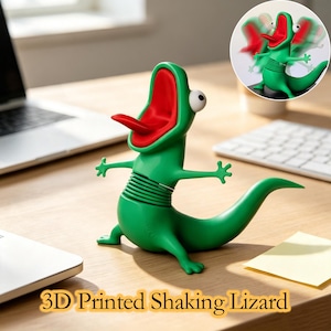 May include: A green 3D printed lizard figurine with a red interior mouth, a protruding tongue, and white eyes. The lizard features a flexible, spring-like midsection that allows for a shaking motion, as shown in the circular inset image.