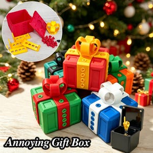 May include: A collection of square gift boxes featuring modular components, including red, green, blue, and white boxes with contrasting bows. One open black box reveals a spring-loaded gold hand figurine. The text Annoying Gift Box is visible.