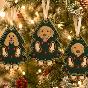May include: Three dark green, tree-shaped embroidered ornaments featuring different dog breeds. Each ornament displays a dog head, two paws, and small red circular accents, finished with a cream-colored ribbon loop for hanging on a tree.