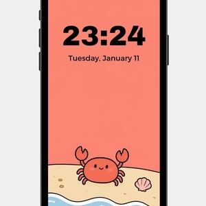 Peut inclure: Un smartphone avec un cadre noir affichant un écran de verrouillage couleur corail. L'écran indique l'heure 23:24 et la date du mardi 11 janvier. En bas, une illustration montre un petit crabe rouge sur une plage de sable avec un coquillage.