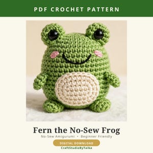 May include: A PDF crochet pattern for Fern the No-Sew Frog, featuring a green amigurumi frog with black eyes, pink cheeks, and a cream-colored belly. The digital download includes the text PDF CROCHET PATTERN and CraftStudioByTaiba.