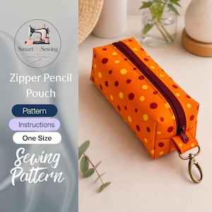 May include: An orange rectangular zipper pencil pouch featuring a pattern of small yellow and dark red polka dots. The pouch has a dark red zipper closure and a metal lobster clasp attached to a fabric tab on the end for easy carrying or attachment.