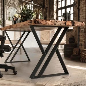 Peut inclure: Une table rectangulaire dotée d'un plateau en bois épais à bord naturel, présentant une finition en écorce brute et texturée sur les côtés. La table est soutenue par deux pieds en métal noir, chacun avec un cadre géométrique angulaire.