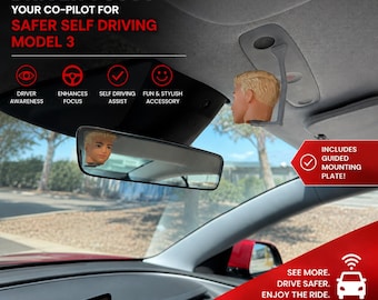 Puede incluir: Un accesorio para el interior del coche con una pequeña cabeza de muñeco rubio montada en el techo cerca del espejo retrovisor. La imagen incluye el texto: DRIVER FOCUS, YOUR CO-PILOT FOR SAFER SELF DRIVING MODEL 3, INCLUDES GUIDED MOUNTING PLATE.