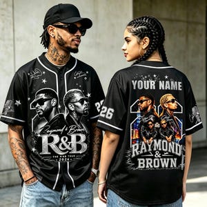 May include: A black baseball jersey featuring a graphic print of two men in sunglasses, the text Raymond & Brown R&B The R&B Tour 2026, and white piping. The back displays the text Your Name, the number 26, and a repeat of the graphic and text.