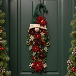 Puede incluir: Un adorno de pared de gnomo tejido a ganchillo con un sombrero puntiagudo de color verde oscuro, borde crema y nariz redonda beige. La barba está compuesta por flores de pascua rojas, hojas de acebo verdes, bayas amarillas y copos de nieve blancos.