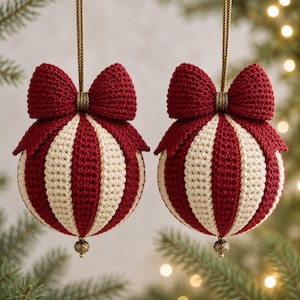 May include: Two spherical crochet ornaments featuring alternating vertical stripes of deep red and cream yarn. Each ornament is topped with a large, matching red crochet bow and hangs from a gold cord, finished with a small, ornate gold bead at the base.