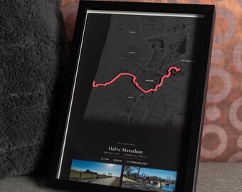 May include: A framed map print featuring a dark gray street layout with a prominent pink line tracing a route. The text reads Halve Marathon, 21.1 KM, 02:18:01, 27 FEBRUARI 2021, and includes two small landscape photographs at the bottom of the frame.