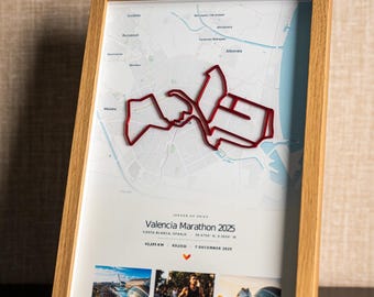 May include: A framed map of the Valencia Marathon 2025 featuring a raised red route outline over a light blue and white city map. The print includes the text Valencia Marathon 2025, 42.195 KM, 03:23:11, 7 December 2025, and three small photos at the bottom.