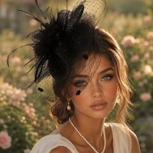 May include: A black fascinator headpiece featuring a structured fabric flower, delicate feathers, and a fine mesh veil that partially covers the face. The accessory is accented with small dark circular embellishments on the netting.