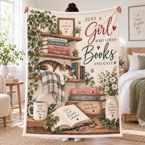 May include: A cream-colored throw blanket featuring a bookshelf illustration with a sleeping cat, potted plants, and books. Text reads: Just a Girl who loves Books and Cats, Sophia, Est. 2020, Collecting Good Stories, and More Kindness Brighter Days.