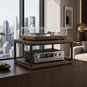 Puede incluir: Un tocadiscos de madera con una cubierta antipolvo de acrílico transparente sobre un soporte de dos niveles de madera y metal negro. Debajo, un receptor de audio plateado con múltiples perillas y dos medidores analógicos en el estante inferior.