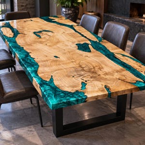 May include: A rectangular dining table featuring a natural light-colored wood slab with live edges and a vibrant, translucent teal epoxy resin river running through the center, supported by a sturdy black metal U-shaped base frame.