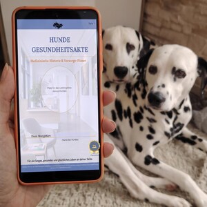 Könnte beinhalten: Ein Smartphone mit orangefarbener Hülle zeigt ein digitales Dokument mit dem Titel HUNDE GESUNDHEITSAKTE, das Abschnitte für medizinische Historie, einen Fotoplatzhalter und ein goldenes Siegel enthält, mit zwei Dalmatinern im Hintergrund.