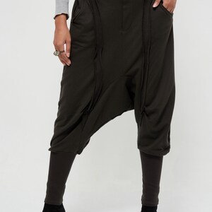 May include: Black, loose-fitting pants with a unique, gathered design. The pants have a high waist and a wide leg.