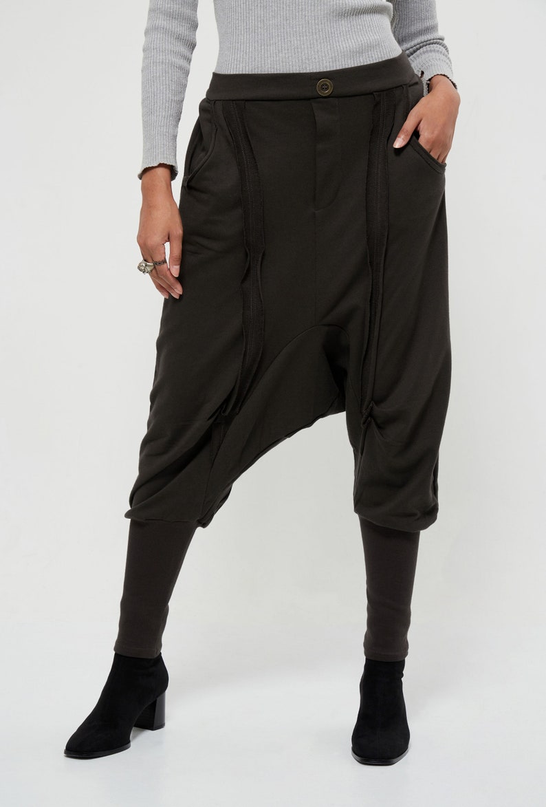 May include: Black, loose-fitting pants with a unique, gathered design. The pants have a high waist and a wide leg.