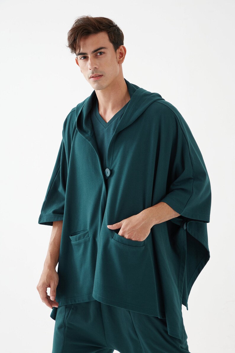 May include: A dark green hooded cardigan with a single button closure and two pockets. The cardigan is made of a soft, comfortable fabric.