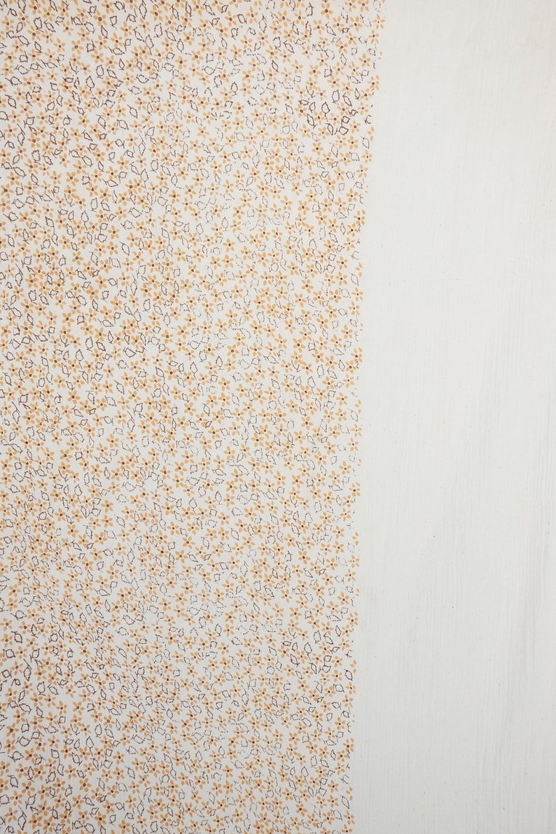May include: White fabric with a small, repeating pattern of brown and yellow flowers.
