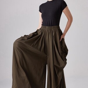 May include: A dark green, flowy, wide-leg pant with a button-up front and a gathered waist.