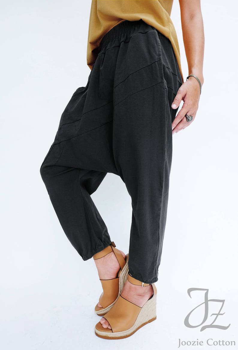 Pu&ograve; includere: Pantaloni in cotone nero con una vestibilit&agrave; ampia e larga, con una cintura elastica a costine. I pantaloni hanno un design unico con cuciture angolate e una lunghezza a met&agrave; gamba.