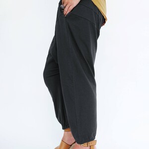 Pu&ograve; includere: Pantaloni neri con orlo a pie e sandalo con zeppa marrone.