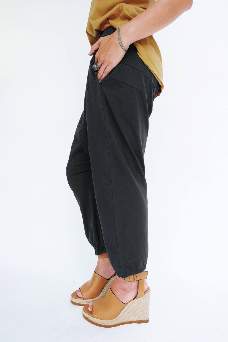 Pu&ograve; includere: Pantaloni neri con orlo a pie e sandalo con zeppa marrone.