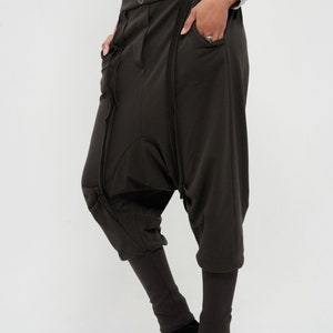 May include: A pair of dark brown, loose-fitting pants with a unique design featuring multiple seams and pockets. The pants are made of a soft, comfortable fabric and have a relaxed fit.