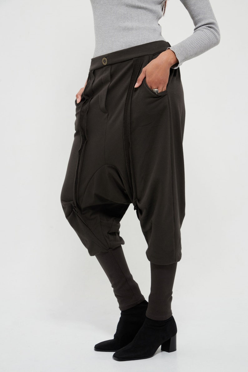 May include: A pair of dark brown, loose-fitting pants with a unique design featuring multiple seams and pockets. The pants are made of a soft, comfortable fabric and have a relaxed fit.