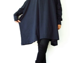 May include: A black long-sleeved tunic top with a relaxed fit and a slightly asymmetrical hemline. The model is wearing black leggings and black heeled shoes.