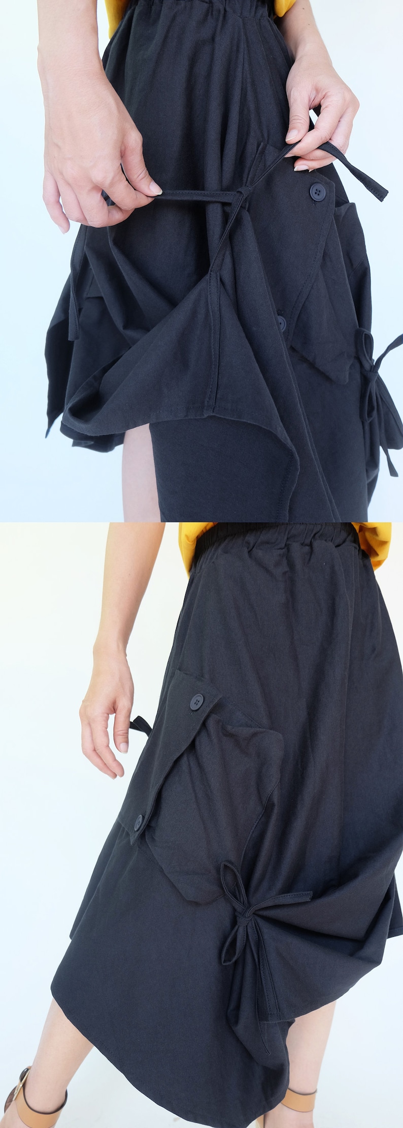 May include: Black skirt with a unique design featuring a large pocket on the side and a tie detail at the bottom. The skirt has a drawstring waist and a relaxed fit.
