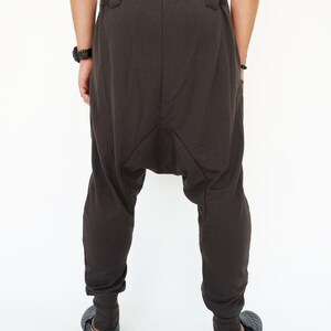 K&ouml;nnte beinhalten: Dunkelbraune, lockere Hose mit einem einzigartigen, gerafften Design im Schritt. Die Hose hat einen Kordelzugbund und eine lockere Passform.