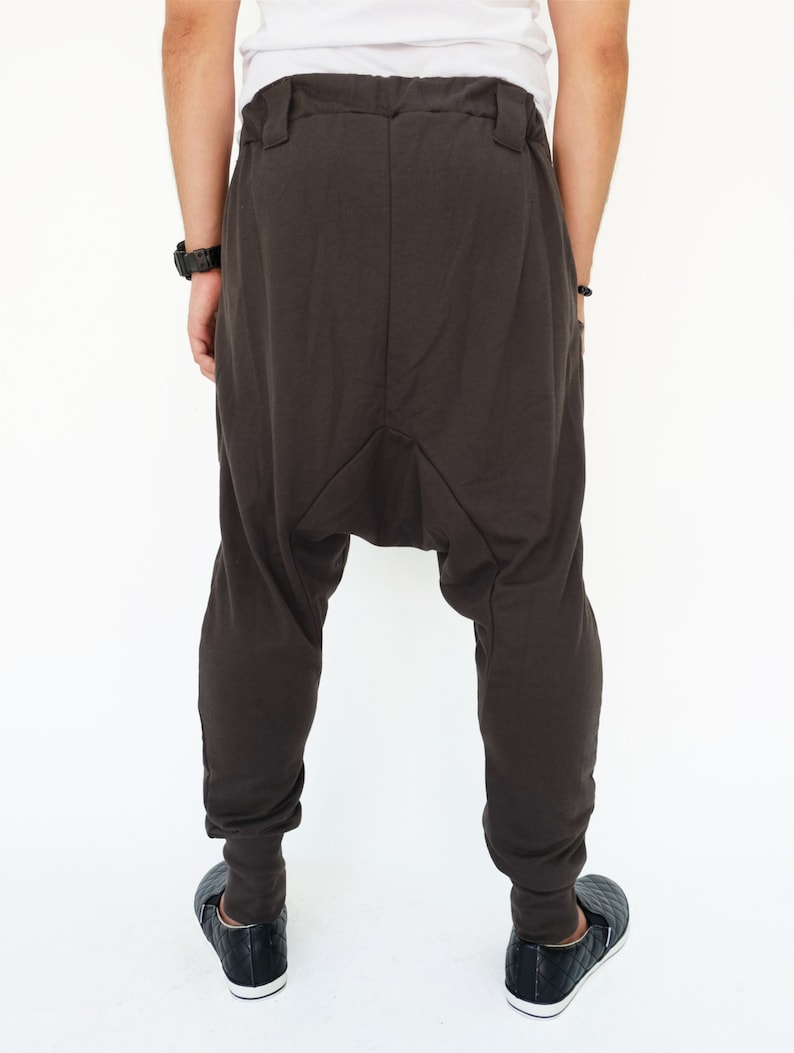 K&ouml;nnte beinhalten: Dunkelbraune, lockere Hose mit einem einzigartigen, gerafften Design im Schritt. Die Hose hat einen Kordelzugbund und eine lockere Passform.