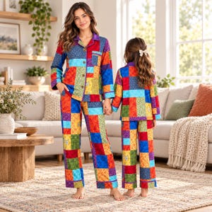 Può includere: Set di pigiami abbinati caratterizzati da un vivace motivo patchwork multicolore con varie stampe floreali e geometriche nei toni del rosso, blu, verde, giallo e viola. I set includono camicie a maniche lunghe e pantaloni lunghi.