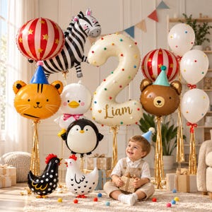 May include: A collection of party balloons including a large cream number two with the name Liam, a zebra, a tiger, a bear, a penguin, a duck, two chickens, and red-striped and white balloons with colorful polka dots.
