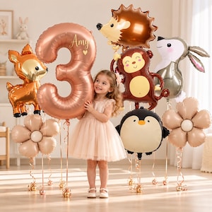 May include: A collection of foil balloons including a large rose gold number 3 with the name Amy printed on it, a brown hedgehog, a brown monkey, a gray rabbit, a black and white penguin, and two beige flower-shaped balloons.