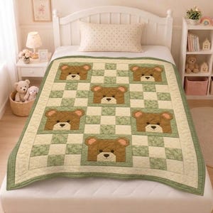 Könnte beinhalten: Eine gesteppte Tagesdecke mit einem sich wiederholenden Muster aus braunen Teddybärengesichtern, die sich mit hellgrünen und cremefarbenen Karofeldern abwechseln. Die Decke hat einen breiten Rand in Salbeigrün und eine gesteppte Textur.