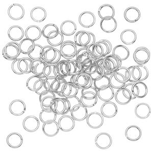 Könnte beinhalten: Eine Ansammlung zahlreicher kleiner, kreisförmiger silberfarbener Metall-Biegeringe, die über den Rahmen verstreut sind. Jeder einzelne Ring weist eine schmale Öffnung auf, die Flexibilität und Verbindung bei der Montage von Schmuckstücken ermöglicht.