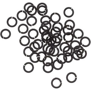 Puede incluir: Una colección de numerosos anillos de salto circulares pequeños de metal negro dispersos por el marco. Cada anillo individual presenta un único corte abierto, lo que permite la conexión y el montaje en joyería o diversos proyectos.