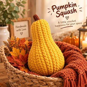 Può includere: Una zucca all'uncinetto gialla con un gambo marrone, posizionata in un cesto intrecciato con foglie d'acero artificiali arancioni e rosse. Il testo nell'immagine recita: Pumpkin Squash, A little crochet happiness for your space, Handmade with Love.