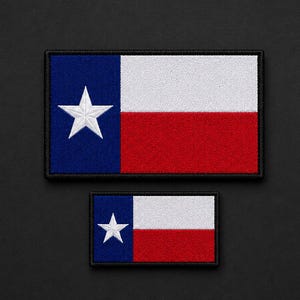 May include: Two rectangular embroidered patches featuring the Texas state flag design. Each patch has a vertical blue stripe on the left with a single white star, and horizontal white and red stripes on the right, all bordered by black stitching.