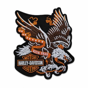 May include: A black embroidered patch featuring a brown and white eagle with wings spread wide. An orange banner across the eagle reads RIDE FREE in white text. Below, an orange and white Harley-Davidson Clothes logo is stitched on black fabric.