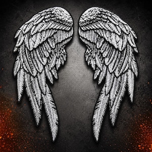 May include: A pair of embroidered patches featuring detailed silver and white angel wings with intricate feather textures. The wings are depicted in a symmetrical arrangement with dark outlines, showcasing a high-contrast design with layered plumage.