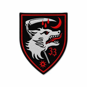 May include: A shield-shaped embroidered patch with a black background and red border. It features a white wolf head with a red tongue, a silver scythe above, three red blood drops, a red crescent moon, a red star, and the red number 33.